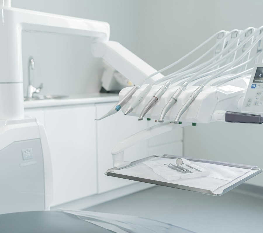 Equipo odontológico branco com instrumentos organizados em um consultório claro